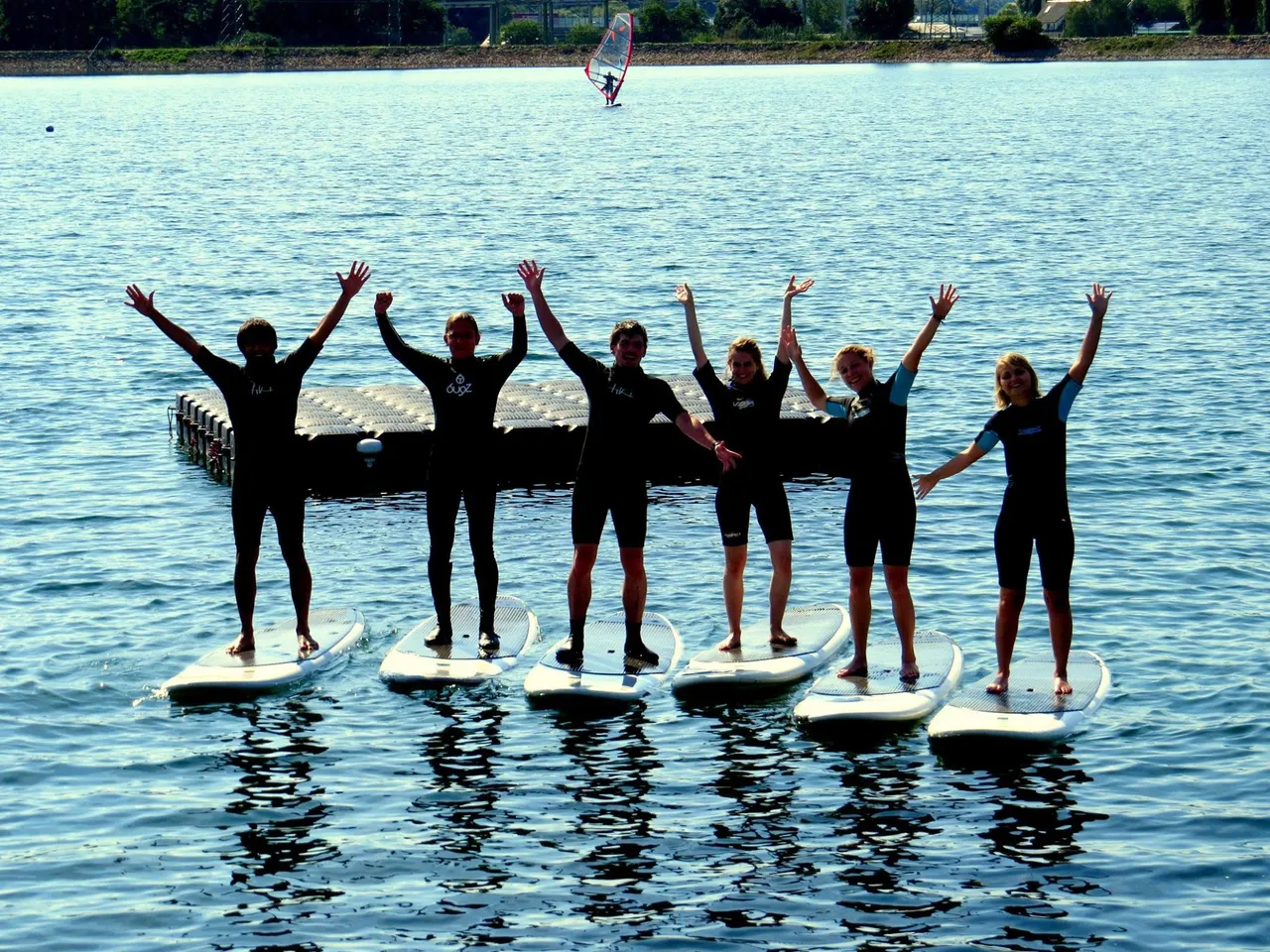 Group of stand-up paddlers cheering on their boards