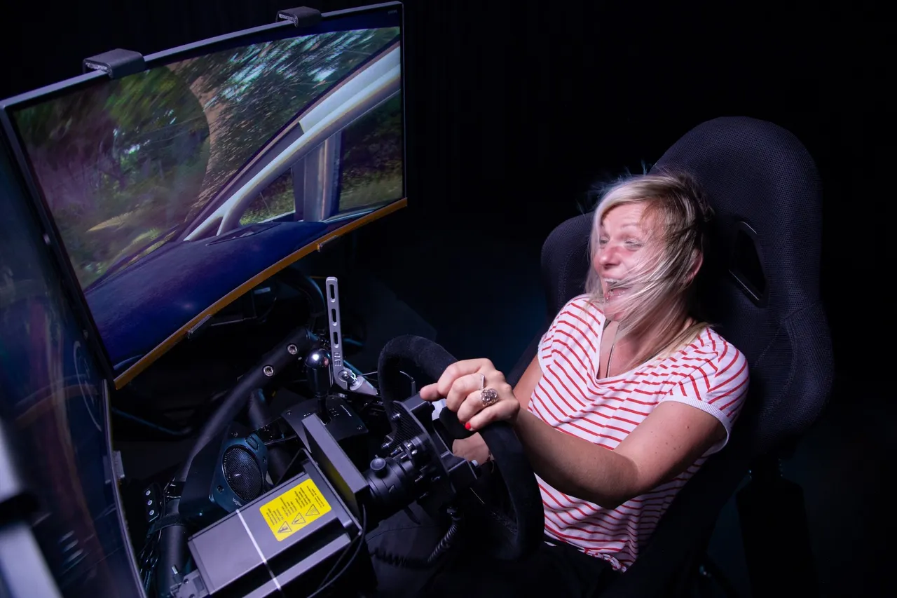 Women driving a Fullmotion racing simulator with wind blowing from the back