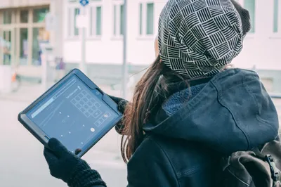woman with hat holding a tablet