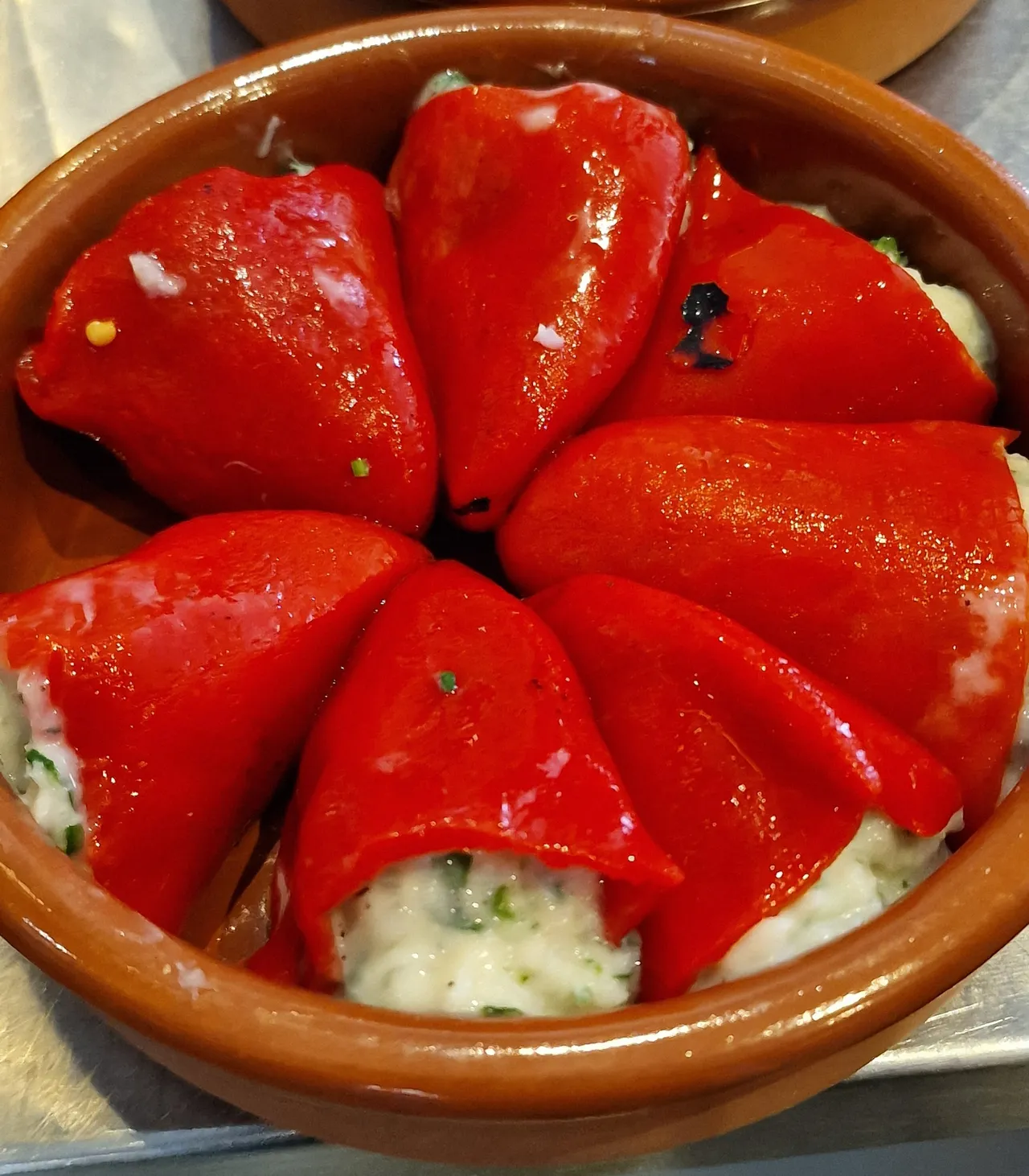 Stuffed red peppers served in tomato sauce