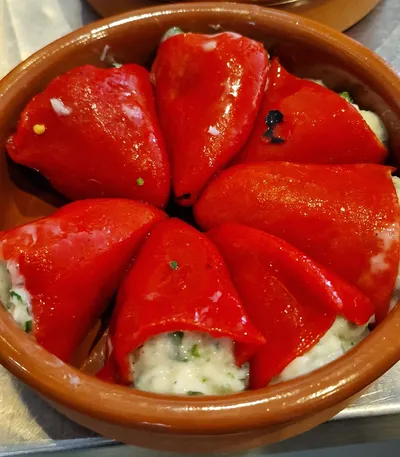 Stuffed red peppers served in tomato sauce