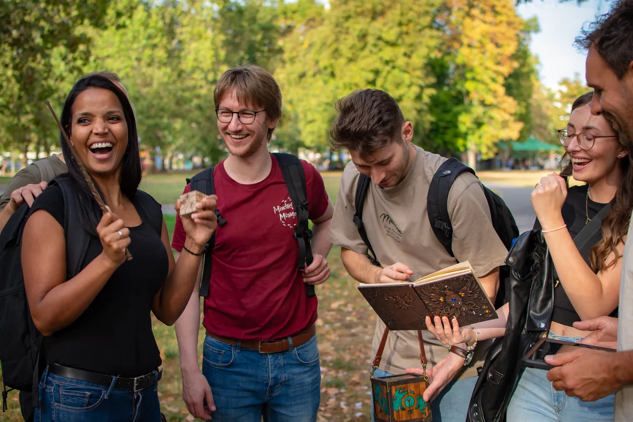 Gruppe lachend mit Zauberstab und Gegenständen