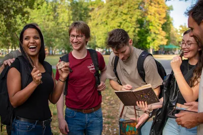 Gruppe lachend mit Zauberstab und Gegenständen