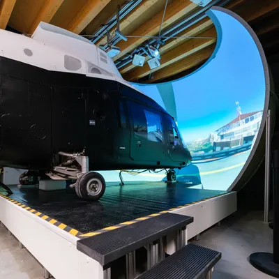 Agusta A109 helicopter simulator in front of a large curved projection dome