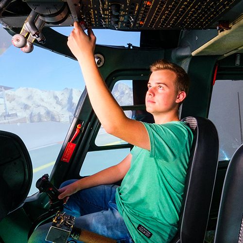Young pilot operating overhead switches in the Agusta A109 helicopter simulator cockpit