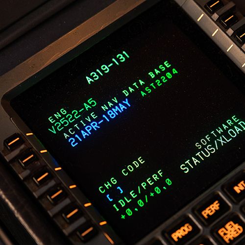 Close-up of the green MCDU flight computer display in the Airbus simulator cockpit