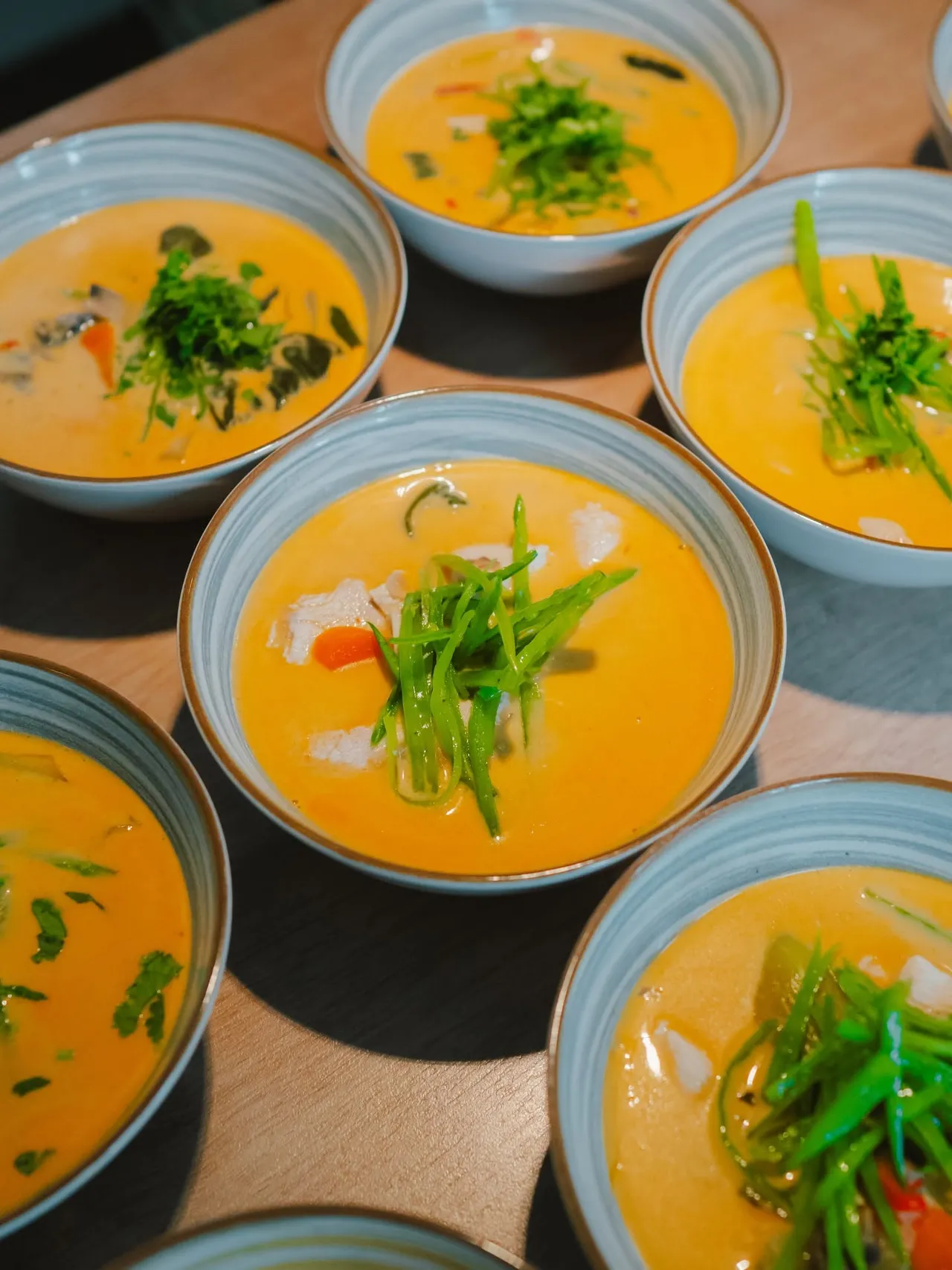 Bowls of creamy curry soup with fresh herbs