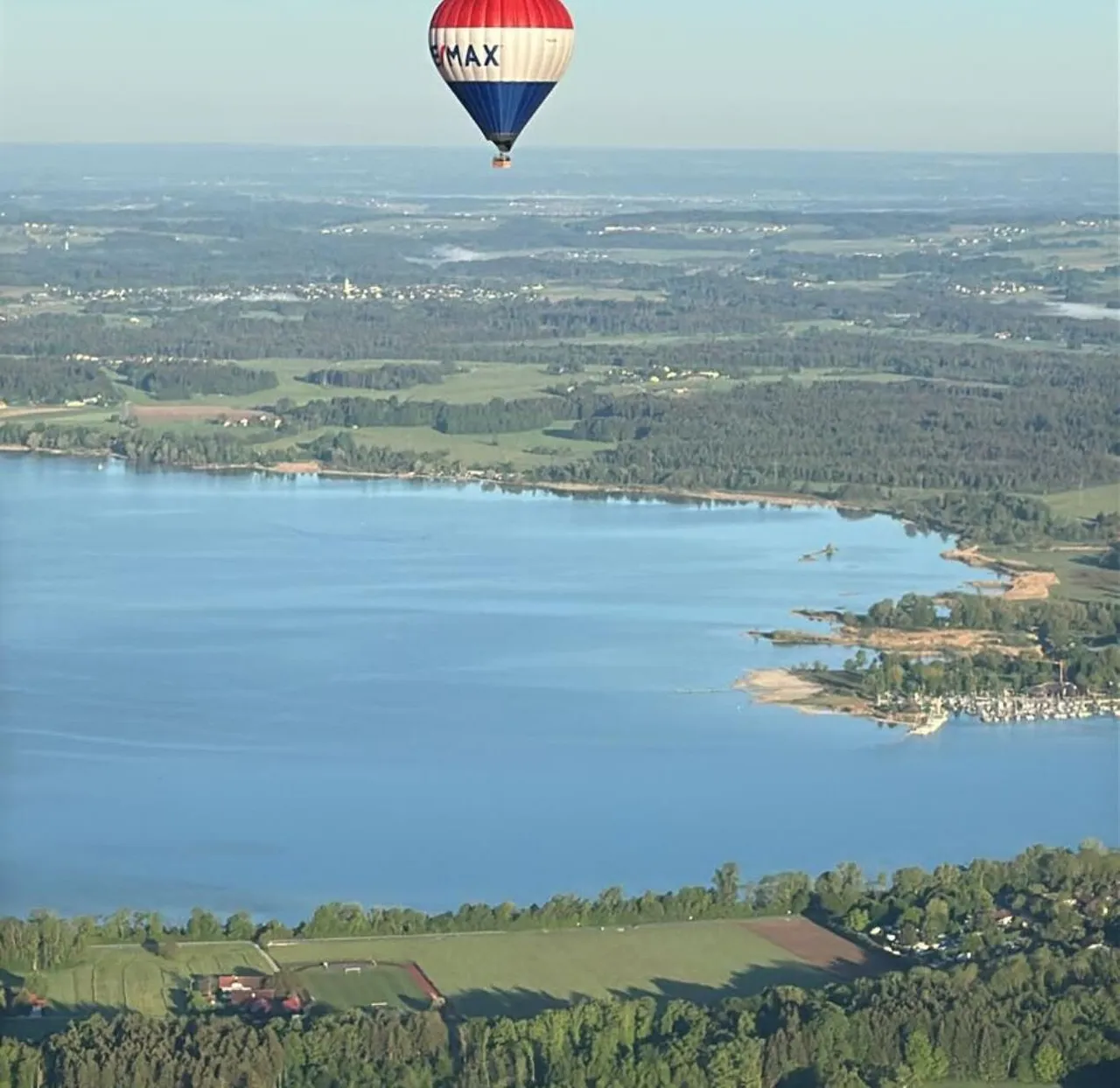 Aerial view of a big lake shoreline with a hot air balloon