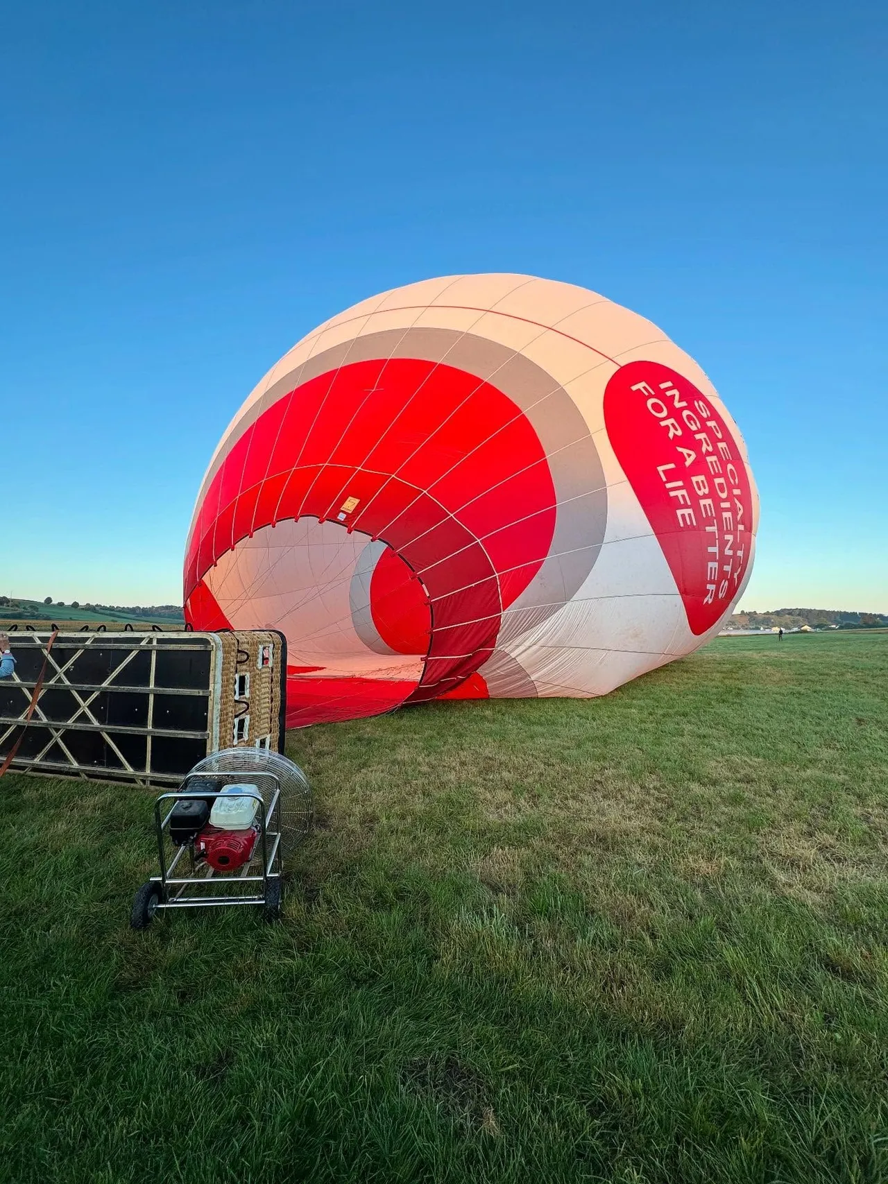 Balloon envelope being inflated on a meadow before takeoff