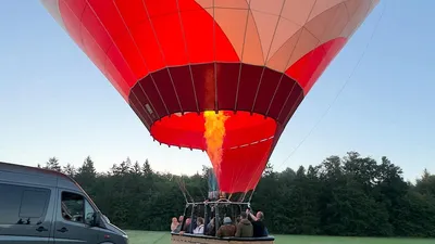 Burner flame heating the balloon with passengers in the basket before takeoff