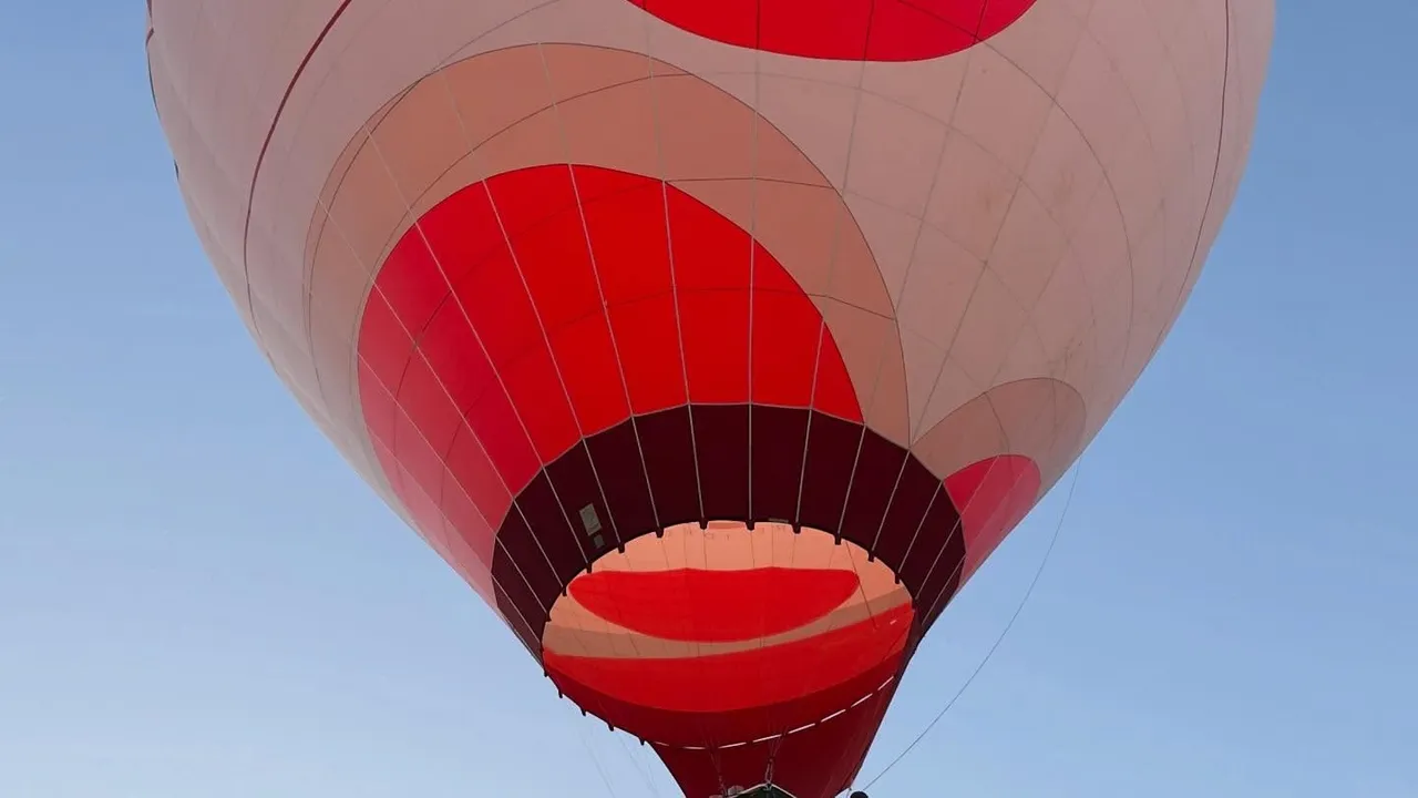 Red and white balloon envelope seen from below