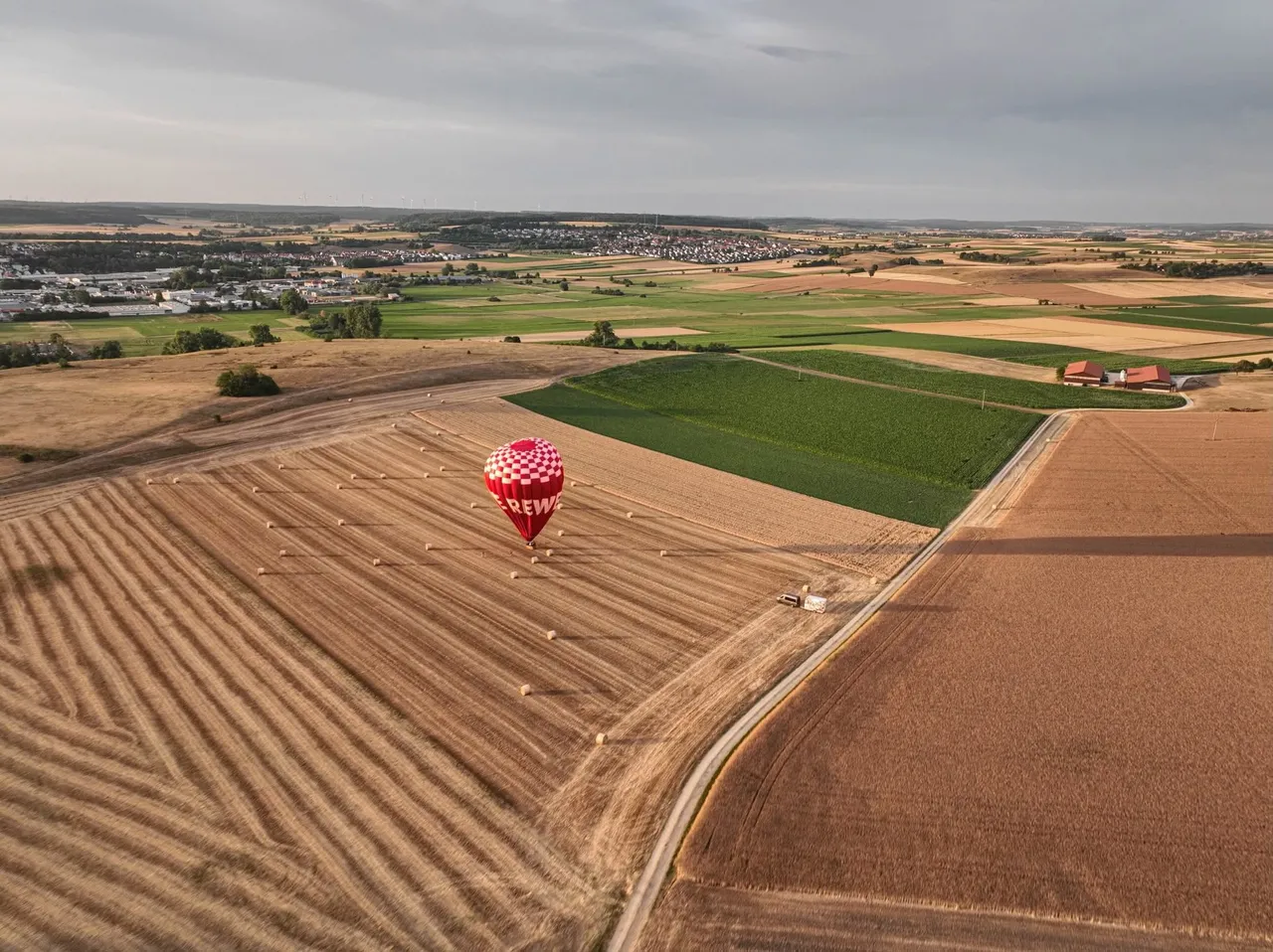 Aerial view of a hot air balloon over harvested fields