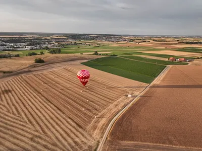 Aerial view of a hot air balloon over harvested fields