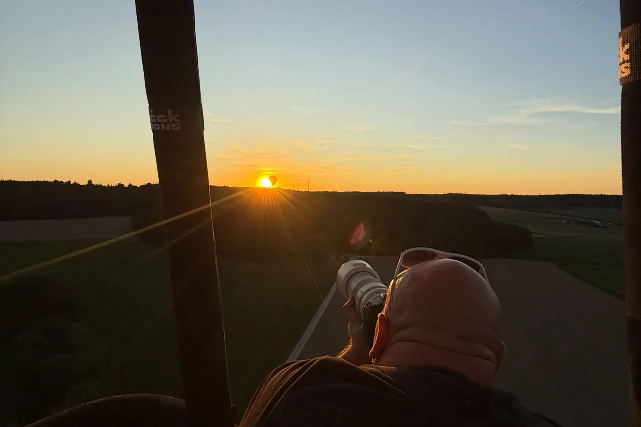 Passenger in the balloon basket watching the sunrise