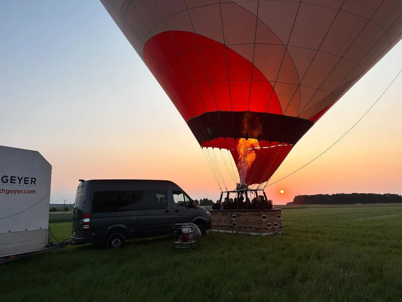Inflated hot air balloon ready for takeoff next to the crew vehicle