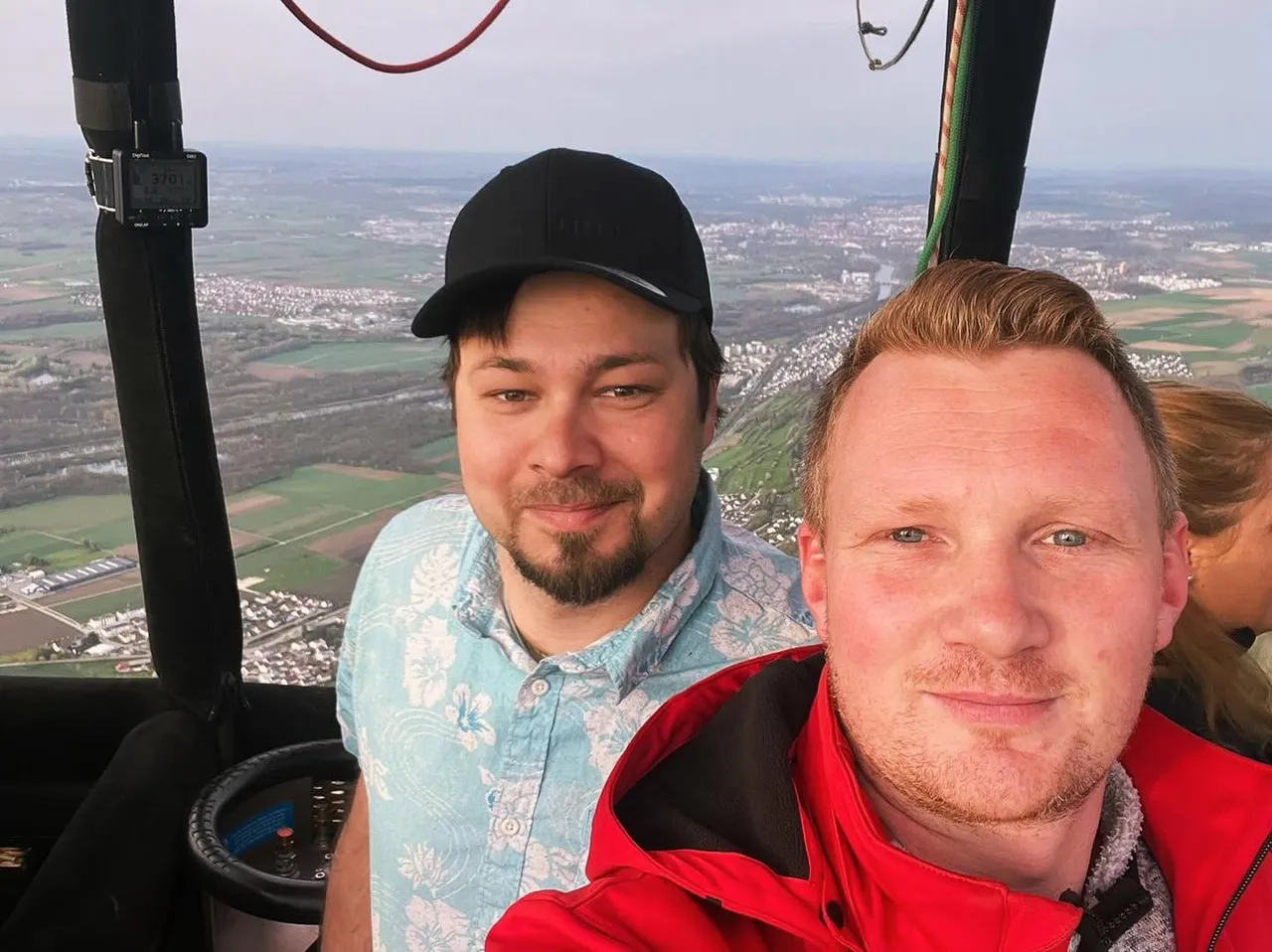 Two passengers taking a selfie in the balloon basket above the countryside