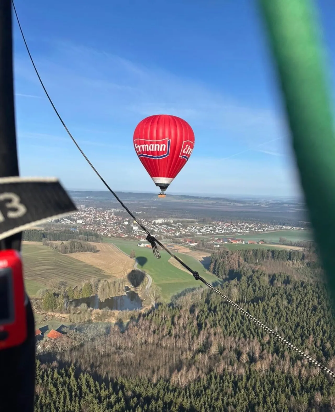 View from the balloon basket of a second balloon above a town