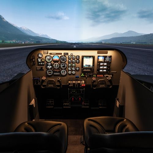 Beechcraft Baron 58 simulator cockpit facing a runway with mountains on the projection screen