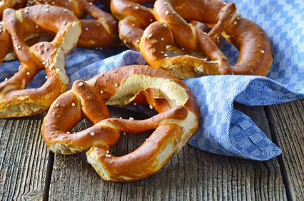 Bavarian pretzels on a blue and white checked cloth on rustic wood