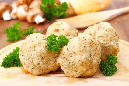 Bread dumplings garnished with fresh parsley on a wooden board