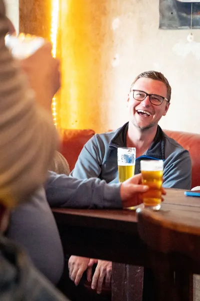 Laughing man with a glass of beer in front of him