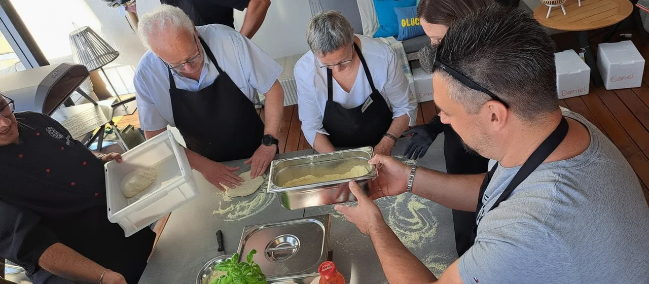 A group of people preparing pizza dough