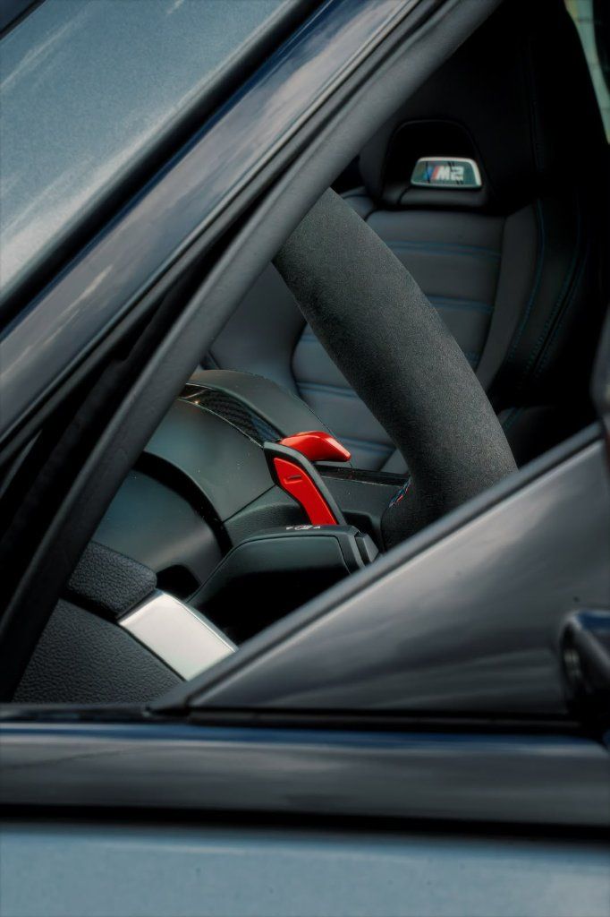 Interior detail of a BMW M2 Facelift 2026 with Alcantara steering wheel and M carbon bucket seat