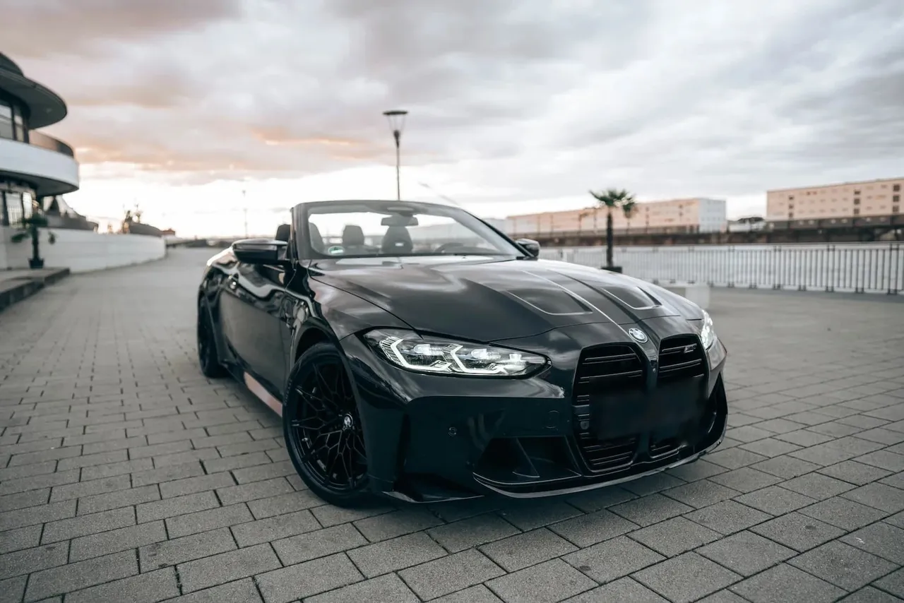 Black BMW M4 Convertible with open top seen from the front right