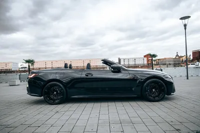Side profile of a black BMW M4 Convertible with the roof down