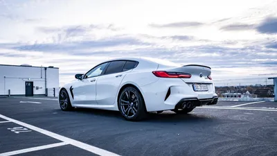 Rear view of a white BMW M8 Competition xDrive showing the M badge and quad tailpipes