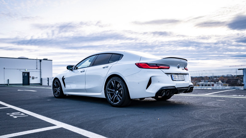 Rear view of a white BMW M8 Competition xDrive showing the M badge and quad tailpipes