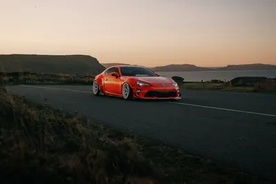 Driving experiences: sports car on a coastal road at sunset