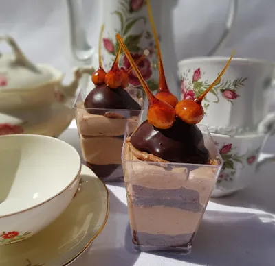 Two desserts with chocolate in cups on a table
