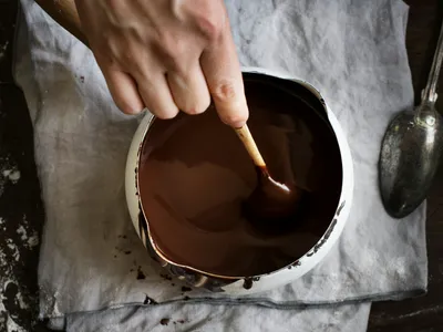 A person stirring a chocolate fondue