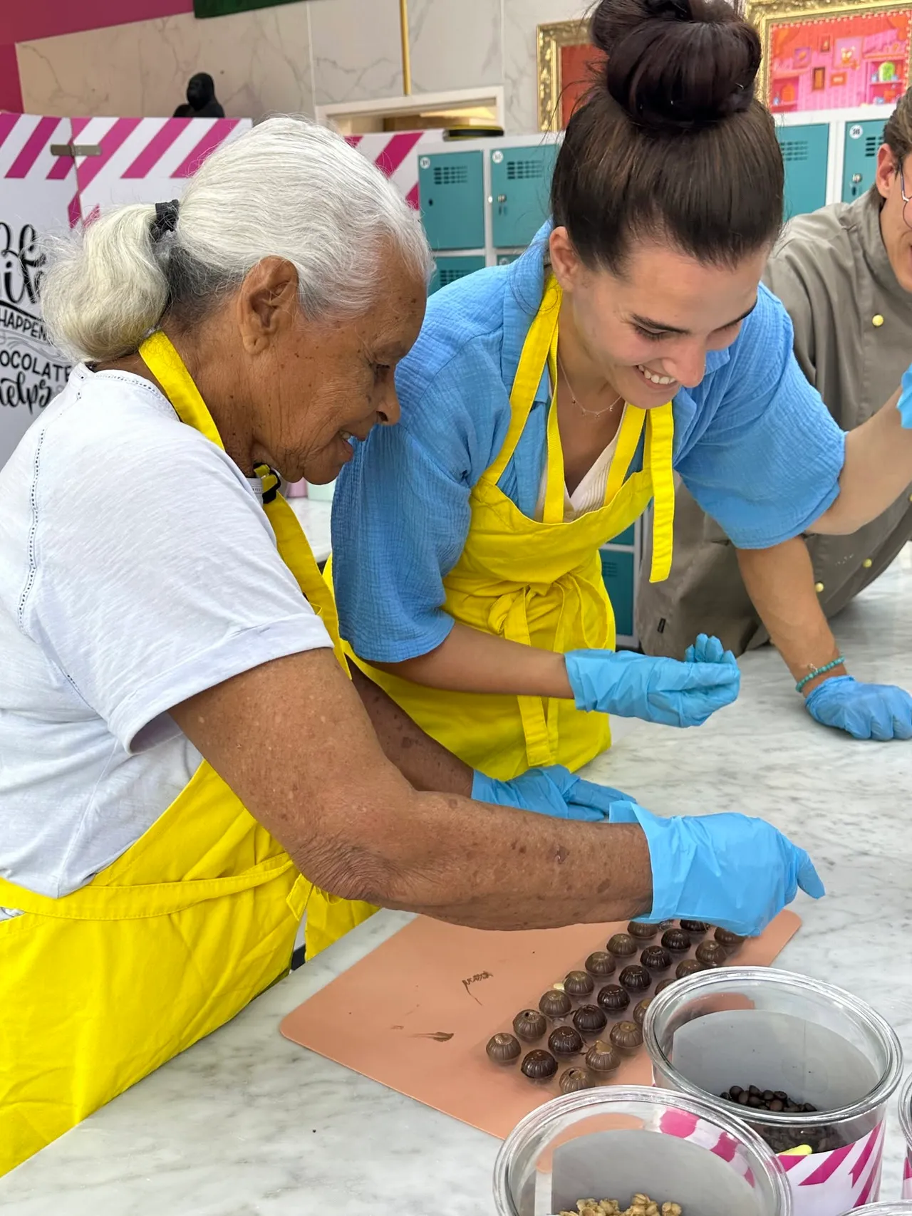 A young and an old woman preparing chocolates