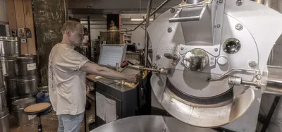A man working at a coffee roasting machine