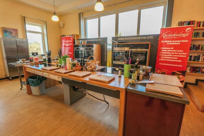Bright cooking school kitchen with a wooden island, cutting boards and built-in ovens