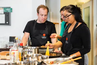 A group of people cooking meat together