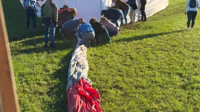 Crew laying out the balloon envelope on the grass