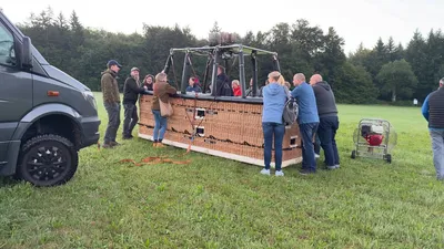 Crew and guests gathering around the balloon basket during setup
