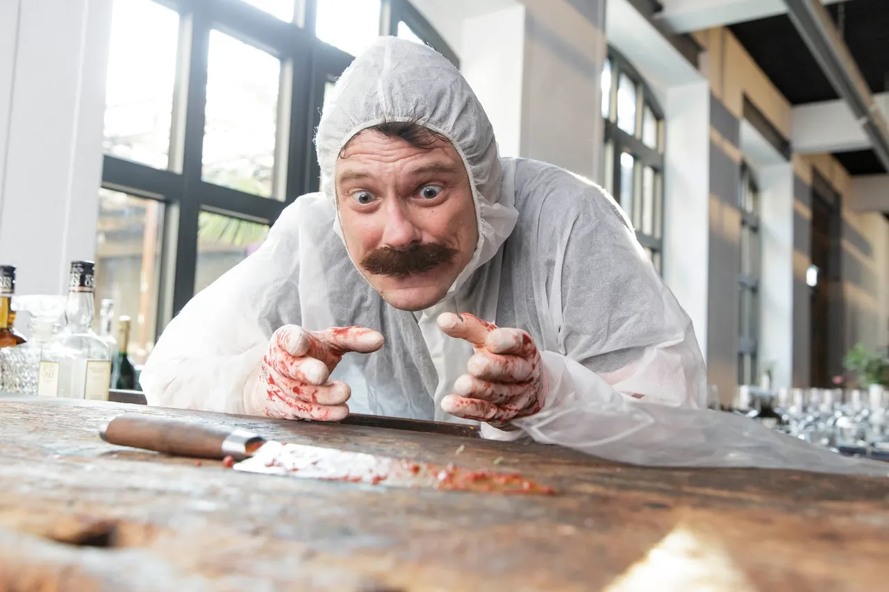 Actor in a white forensic suit with fake blood on his gloves next to a knife at a crime dinner