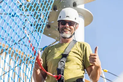 Man on a climbing tower with a white helmet