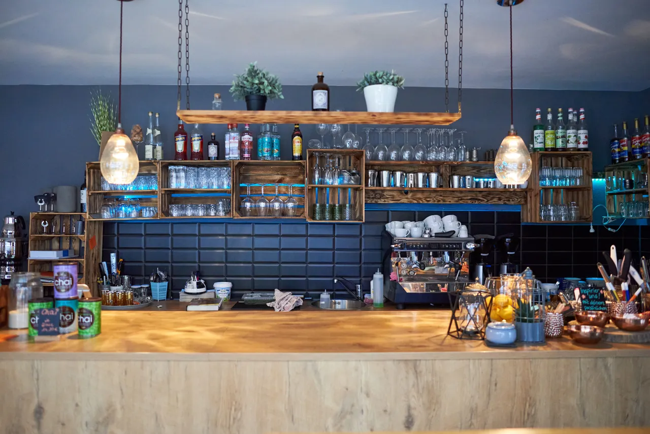 Cosy café counter with wooden shelves and pendant lights