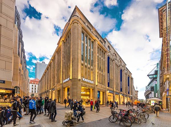 Busy pedestrian shopping street with a historic department store in Leipzig city centre