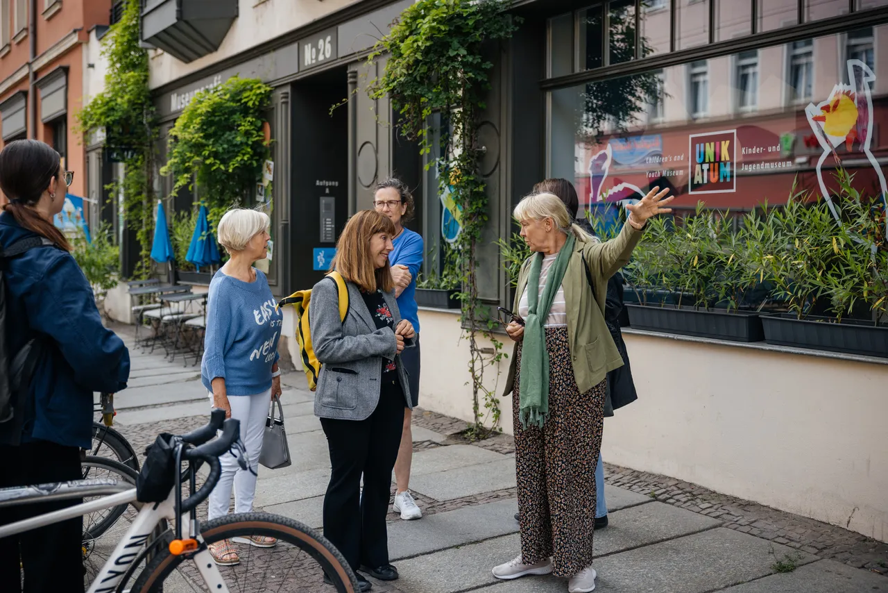 Tour guide explaining the neighbourhood to a small group on a street in Leipzig-Plagwitz