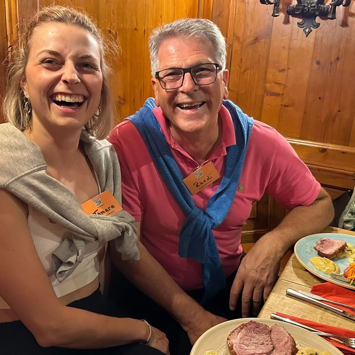 Two people laughing over a meal