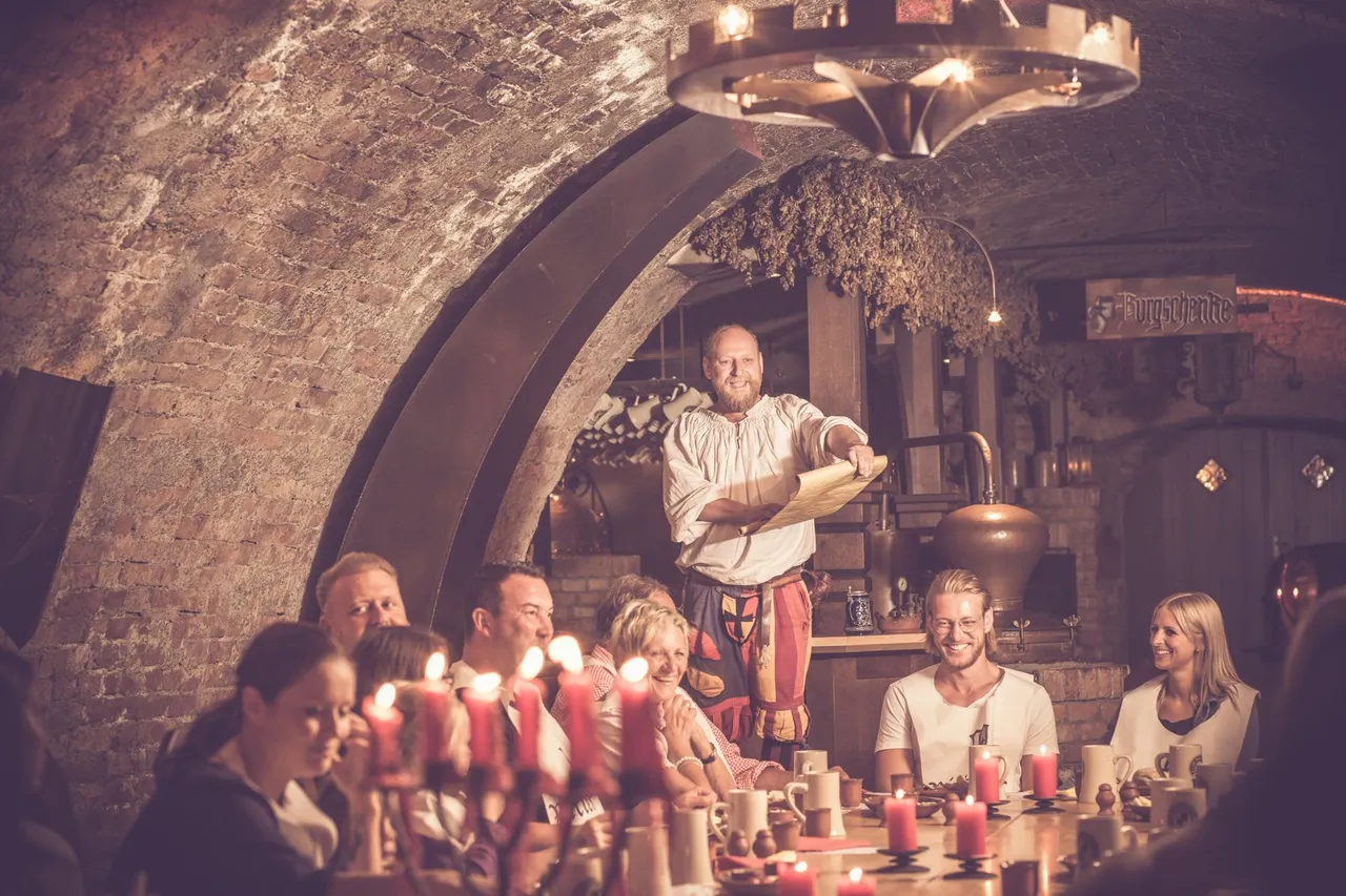 guests.jpg Cupbearer addressing guests at candlelit tables in the vaulted cellar