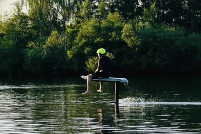 A person sitting on a eFoil board