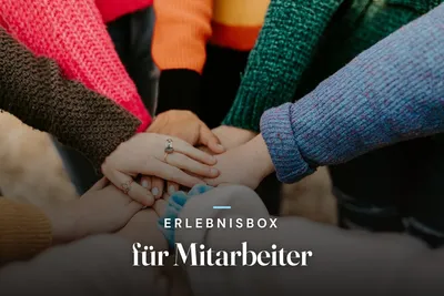Experience gift box for employees – team stacking hands in colourful knitted sweaters