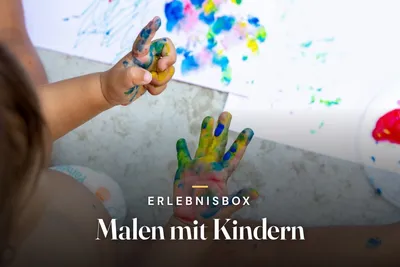 Small child's hands covered in colourful finger paint above a sheet of paper with splashes of blue, yellow and pink, with the title "Erlebnisbox Malen mit Kindern".